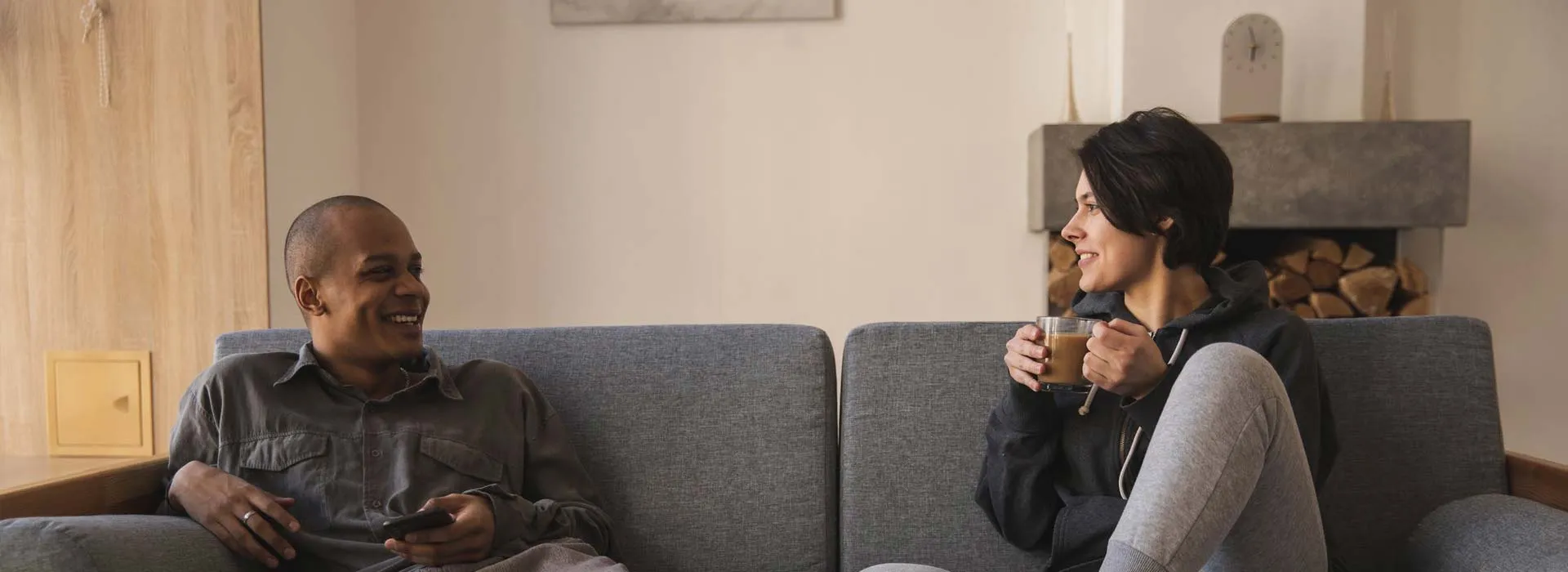 Two people relaxing with coffee on a sofa in their apartment